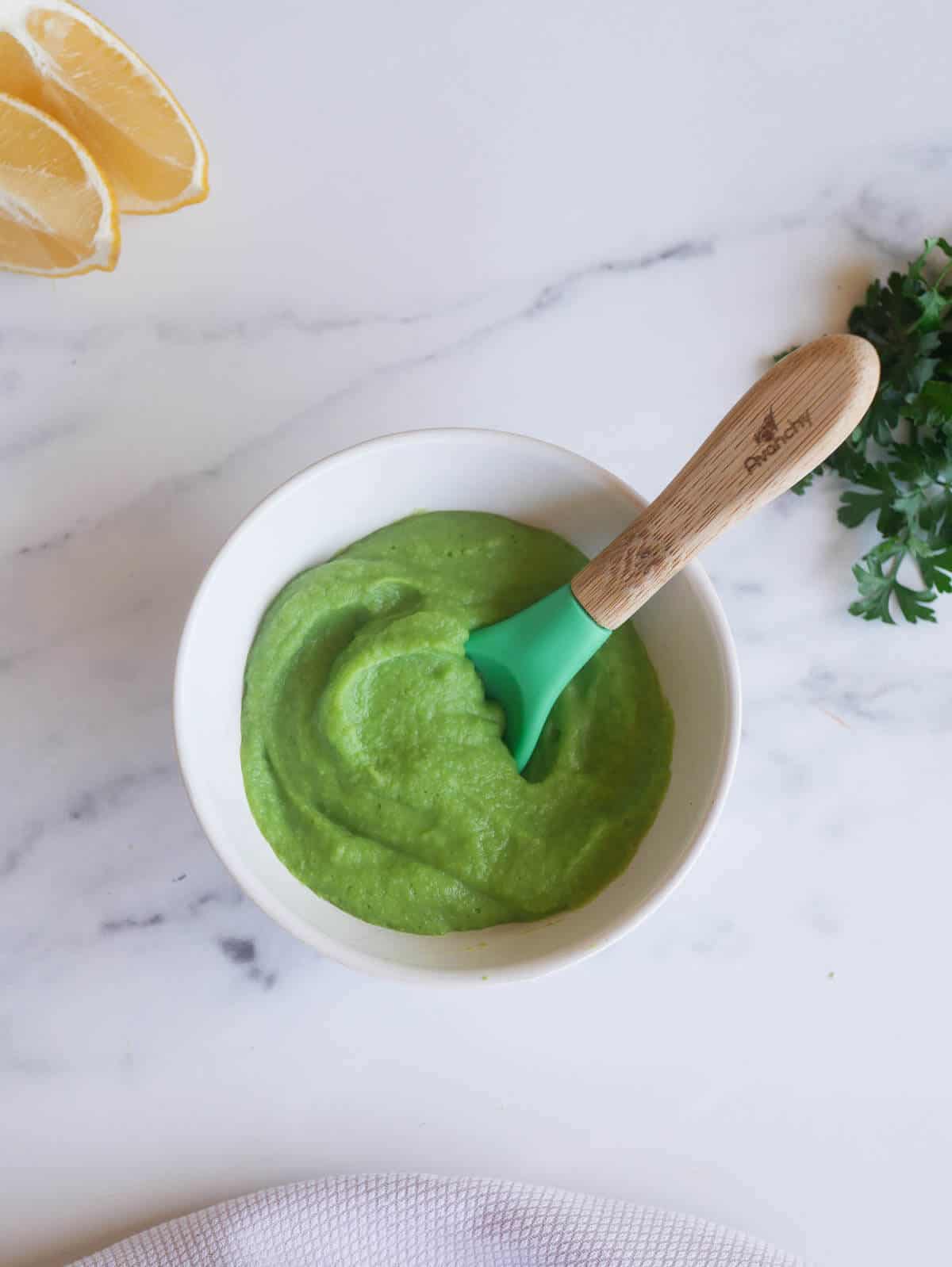 green baby food puree with spoon dipped in